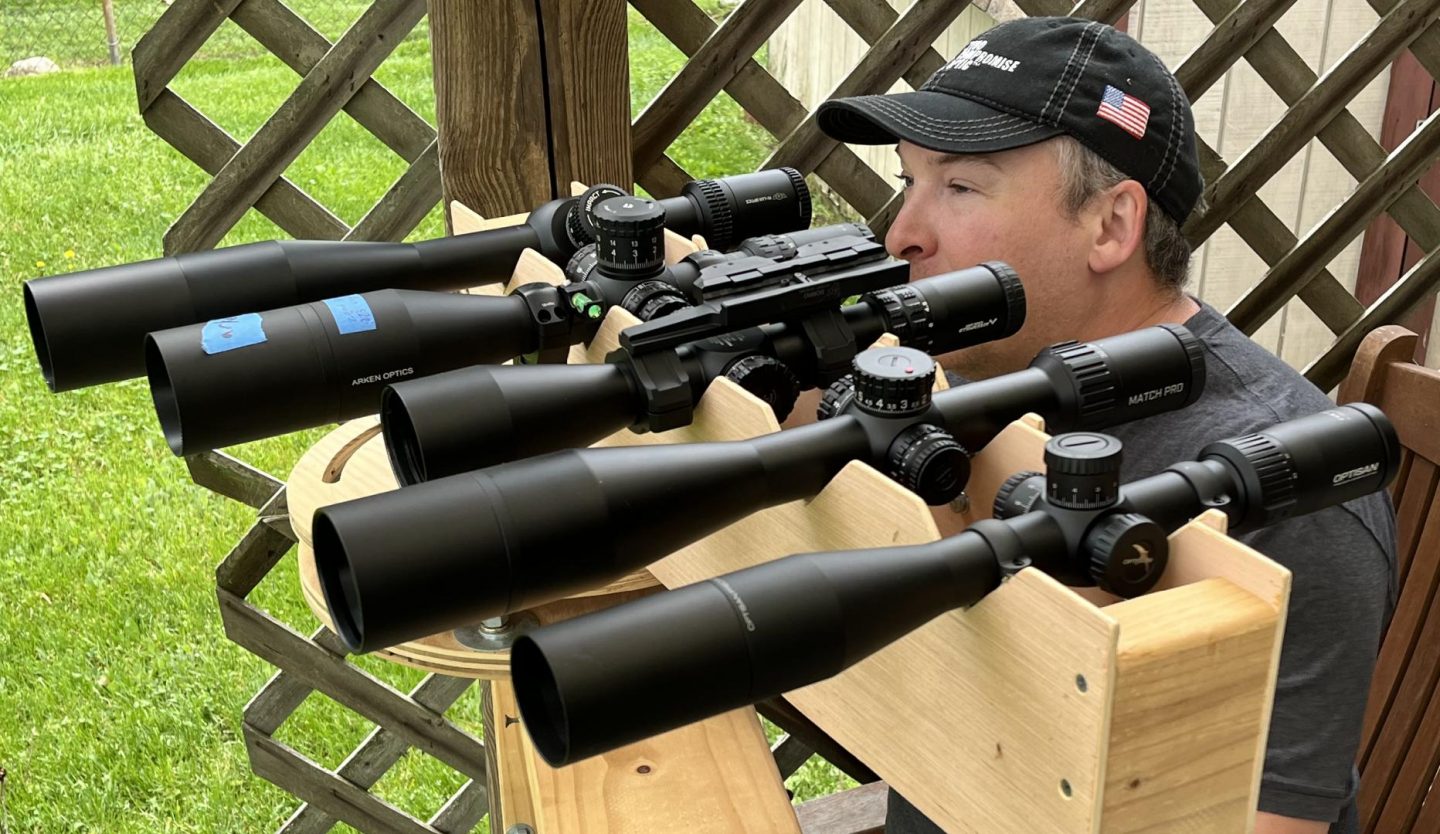 One of the optical test lineups. From top to bottom: Hi-Lux PR5 5-25x56, Arken EP-5 5-2556, Primarly Arms GLx 3-18x44, Bushnell Match Pro ED 5-30x56, and Optisan EVX Gen 2 4-16x44 F1