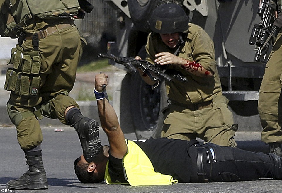 2D79CD4D00000578-3275687-A_bloodied_soldier_grimaces_after_a_man_in_a_press_T_shirt_was_s-a-1_...jpg